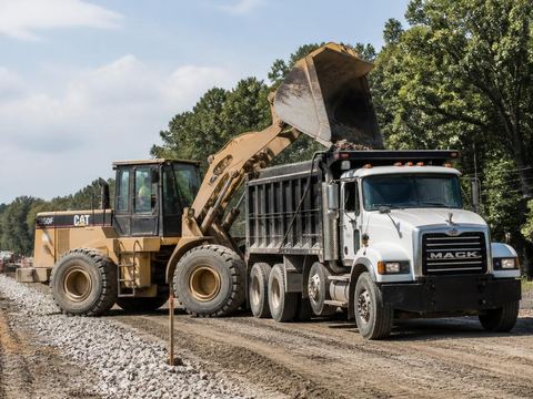 Bucket tractor and truck working on a road construction site